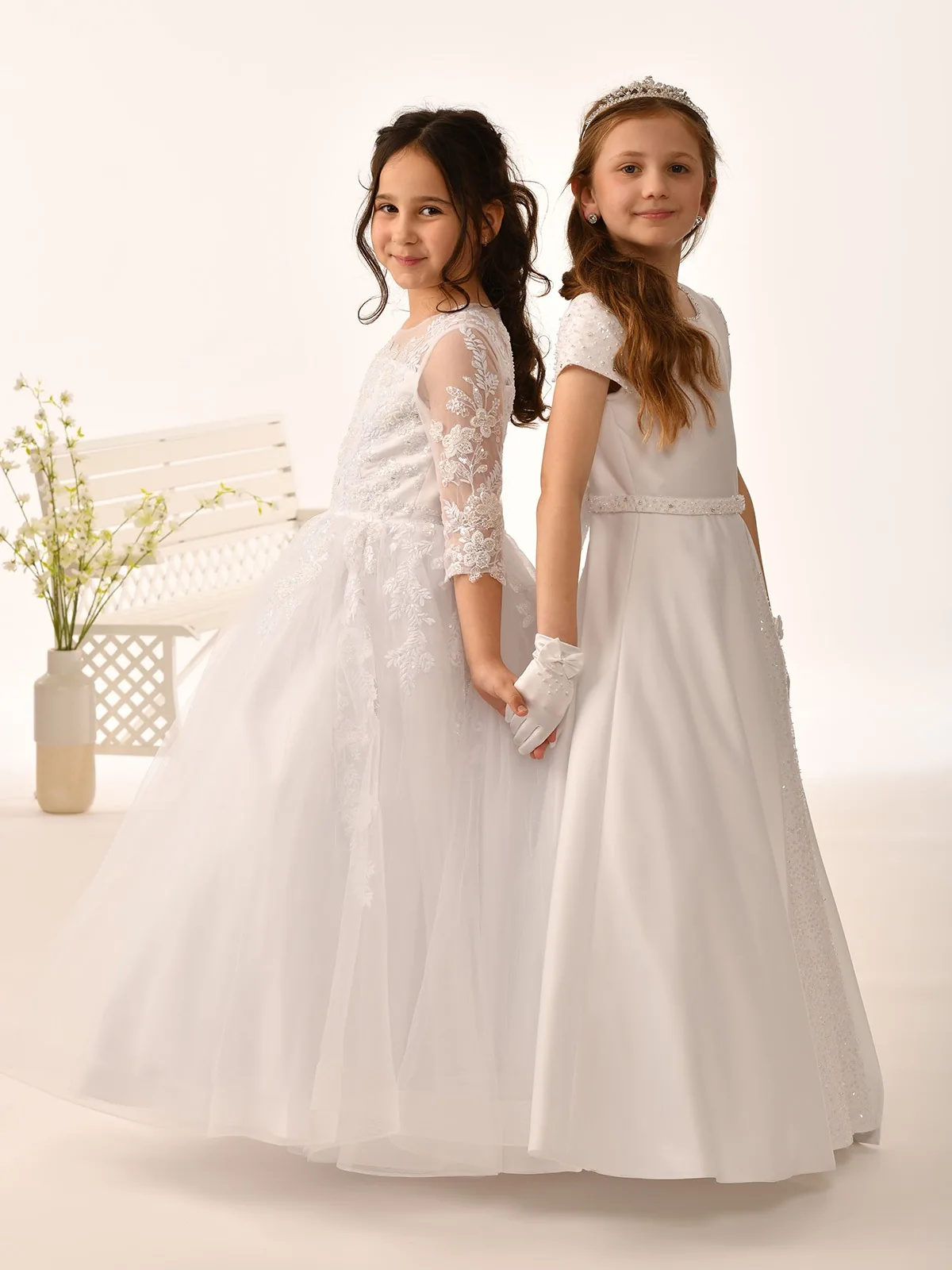 Two young girls in elegant white dresses